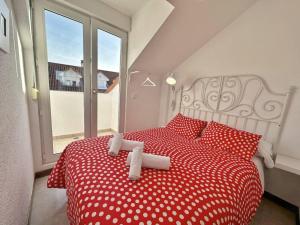 a bedroom with a red and white bed with red pillows at Duplex primera linea La Arena 4607 in Arnuero +26 photos