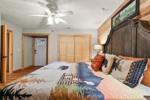 a bedroom with a large bed with a ceiling fan at Hillside Happiness GameRoom Grill Firepit MORE in Sevierville