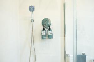 a shower with two bottles of wine hanging on a wall at Villetta Caterina in Procida +40 photos
