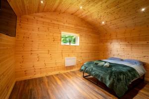 a bedroom with a bed in a wooden room at The Cabin in Mountfield