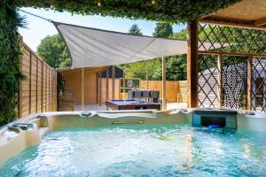 a hot tub in a backyard with an umbrella at The Cabin in Mountfield