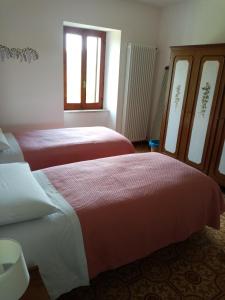 a bedroom with two beds and a window at Casa del Gigi BnB in Albareto