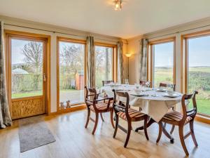 a dining room with a table and chairs and windows at 3 Bed in Gordon oc-82788 in Gordon