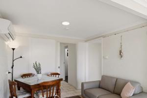 a living room with a couch and a table at Bayview Nook Tanilba Bay in Lemon Tree Passage +10 photos
