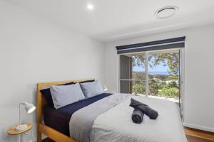 a bedroom with a large bed with a window at Lakeview Luxury in Budgewoi
