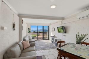 a living room with a couch and a table at Bayview Nook Tanilba Bay in Lemon Tree Passage
