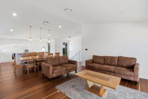 a living room with two couches and a table at Lakeview Luxury in Budgewoi