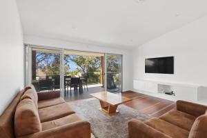 a living room with a couch and a table at Lakeview Luxury in Budgewoi
