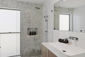 a bathroom with a sink and a shower at Lakeview Luxury in Budgewoi +17 photos