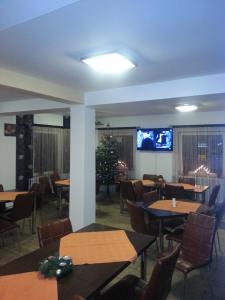 a restaurant with tables and chairs and a christmas tree at Vila MDM in Straja