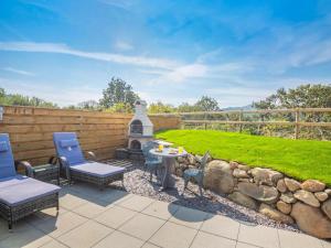 a patio with a table and chairs and a stone wall at 1 Bed in Conwy oc-95221 in Conwy