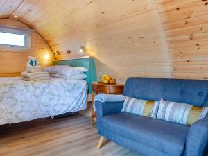 a bedroom with a bed and a blue couch at 1 Bed in Conwy oc-95221 in Conwy