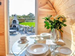 a table with plates and a vase of flowers at 1 Bed in Conwy oc-95221 in Conwy