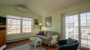 a living room with a couch and chairs and windows at Walk to Willard Beach in South Portland