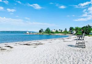 a chair sitting on a beach next to the water at Walk to Willard Beach in South Portland +6 photos