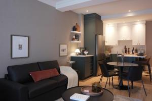 a living room with a couch and a table and a kitchen at Studio 27 in Magog-Orford