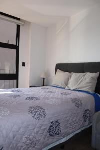 a bedroom with a bed with a blue and white comforter at EON one bedroom aparment 905 in Estación Pamplona +3 photos