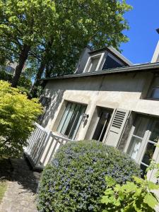 a gray house with a white door and a bush at La Maison des Rues Pavées avec jardin by La Boîte En Plus in Senlis +92 photos