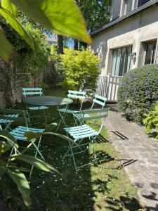 a table and chairs in a yard with a table and chairs at La Maison des Rues Pavées avec jardin by La Boîte En Plus in Senlis