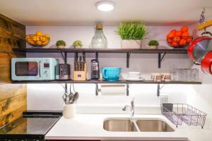 a kitchen with a sink and shelves on the wall at Teton Tiny Home | Jackson, Targhee, Yellowstone in Victor +29 photos