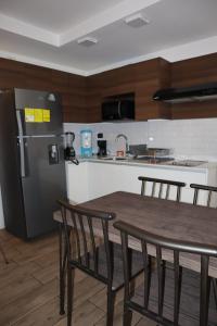 a kitchen with a wooden table and a refrigerator at EON one bedroom aparment 905 in Estación Pamplona