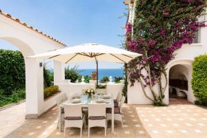 a patio with a table and an umbrella at Villa Elena by MyVillaCollection in Capri +42 photos