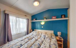 a bedroom with a bed and a blue wall at Lovely Stacaravan In La Tremblade in La Tremblade