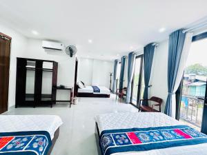 a hotel room with two beds and a balcony at Mộc Hưng Homestay in Bắc Hà