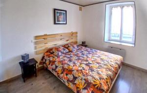 a bedroom with a bed with a colorful comforter and a window at Location Cosy De Plain-Pied in Audincourt