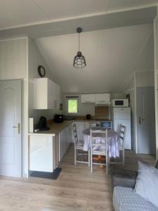 a kitchen and living room with a table and a couch at Chalet cosy in Lissac-sur-Couze