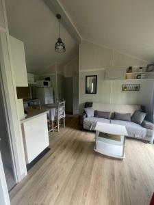 a living room with a couch and a table at Chalet cosy in Lissac-sur-Couze