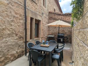 a table with chairs and an umbrella on a patio at Tierra de Pinares 2 in Vinuesa