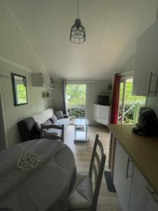 a kitchen and a living room with a table and chairs at Chalet cosy in Lissac-sur-Couze