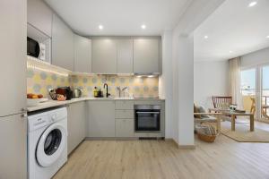 a kitchen with a washing machine and a washer at Casinha da Praia da Rocha in Praia da Rocha