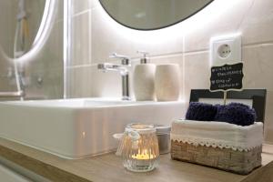 a bathroom with a sink and a counter with a candle and towels at Casinha da Praia da Rocha in Praia da Rocha +17 photos