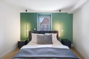 a bedroom with a bed with green walls and a window at Kaisers Anwesen in Vogtsburg