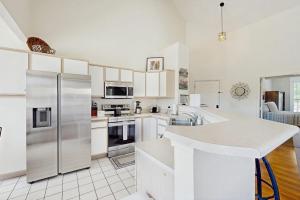 a kitchen with white cabinets and a stainless steel refrigerator at Shoreline Haven in Kimberling City