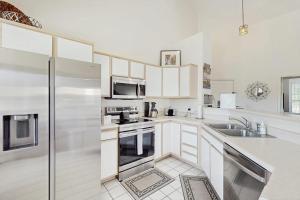 a kitchen with white cabinets and a stainless steel refrigerator at Shoreline Haven in Kimberling City +17 photos