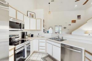 a kitchen with white cabinets and a sink at Shoreline Haven in Kimberling City