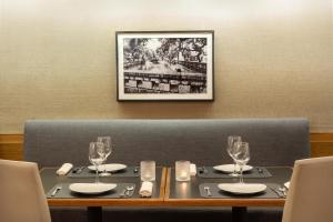 a table with two plates and wine glasses on it at NH Córdoba Panorama in Córdoba +23 photos