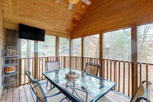 a dining room with a glass table and chairs on a porch at Lost Creek Haven in Branson West
