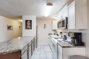 a kitchen with white cabinets and a counter top at Escape to Notch Estates in Branson West +24 photos