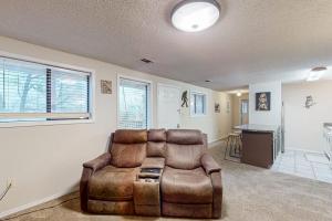 a living room with a leather chair and a table at Escape to Notch Estates in Branson West