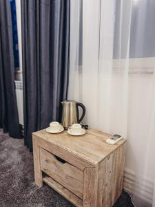 a wooden table with a tea kettle and plates on it at Pushkin Hotel Yerevan in Yerevan