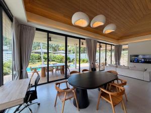 a living room with a table and chairs at MoonLight Villa - 3BR Tropical Pool Retreat in Ko Phangan