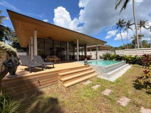 a house with a wooden deck and a swimming pool at MoonLight Villa - 3BR Tropical Pool Retreat in Ko Phangan