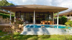 a house with a swimming pool in the yard at MoonLight Villa - 3BR Tropical Pool Retreat in Ko Phangan