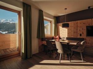 a dining room with a table and chairs and a window at Lechthaler Apartments in Resia