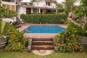a swimming pool in the yard of a house at Ankola Hotel in Homagama