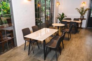 a row of tables and chairs in a room with windows at Ankola Hotel in Homagama